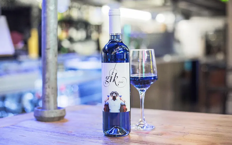 Blauwe wijn in fles en wijnglas
